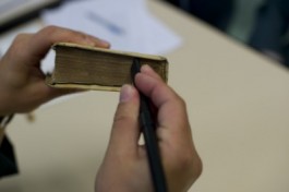 Stofzuigen van de snede van een oude druk in de Provinciale Bibliotheek Limburg | © Vlaamse Erfgoedbibliotheek – Fotografie: Stefan Tavernier Stofzuigen van de snede van een oude druk