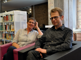 een vrouw en een man kijken glimlachend naar de fototoestel