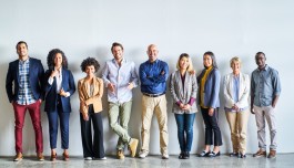 Diverse groep professionals op een rij voor een muur