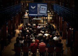 Mensen in een zaal bekijken een presentatie op een scherm