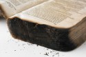 Opengeslagen boek met brandschade aan de ondersnede
